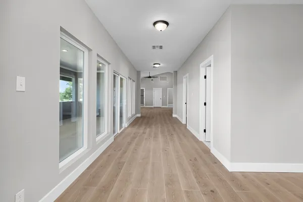 a view of a hallway with wooden floor