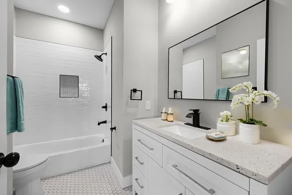 a bathroom with a sink a tub and a mirror