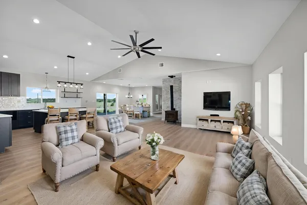 a living room with furniture a flat screen tv and kitchen view