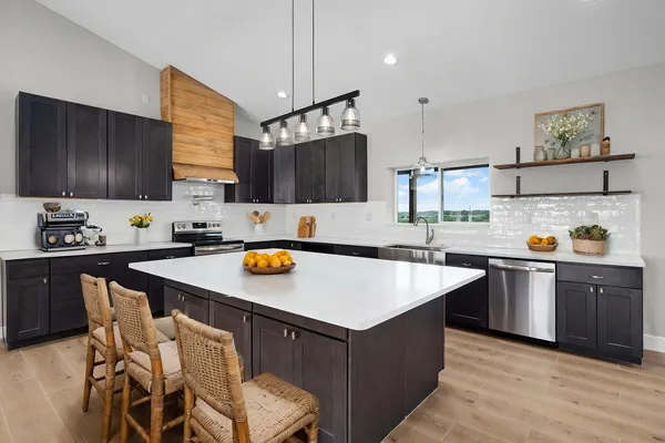 a kitchen with a sink a stove a refrigerator and chairs