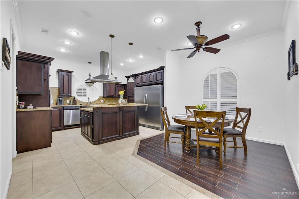 2405 West Rhin Drive Edinburg, TX 78539 - Photo 10 of 26 a kitchen with stainless steel appliances granite countertop a table chairs sink and cabinets
