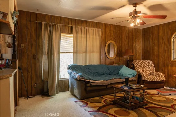 a bed sitting in a room next to a window and a mirror