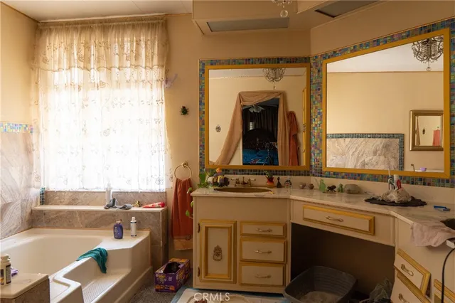 a bathroom with a tub sink and mirror