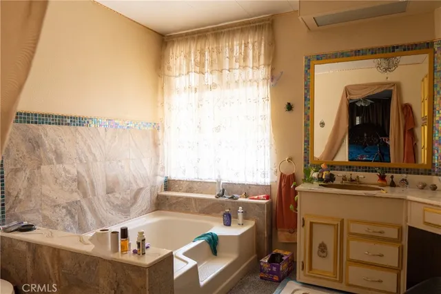 a bathroom with a tub sink and mirror