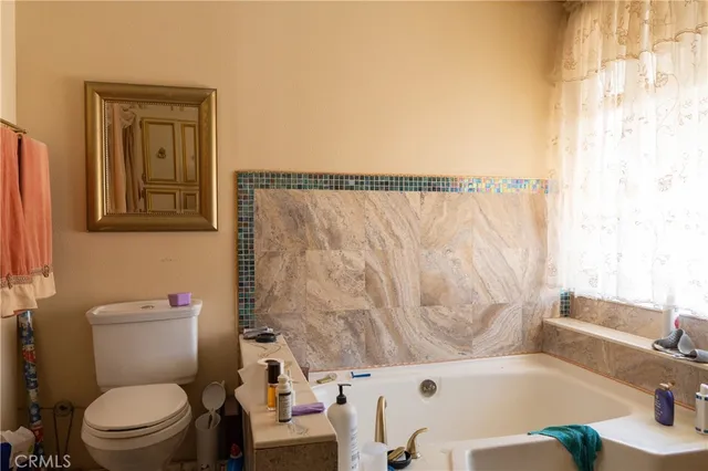 a white toilet sitting next to a bath tub