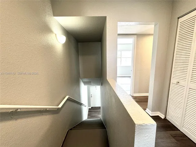 a view of a hallway with furniture and a window