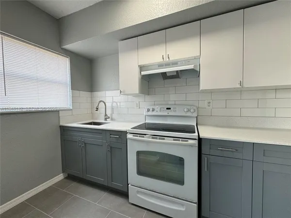 a kitchen with stainless steel appliances granite countertop a sink a stove and cabinets