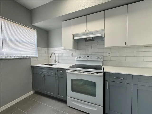 a kitchen with stainless steel appliances granite countertop a sink a stove and cabinets