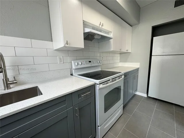 a kitchen with a sink cabinets and appliances