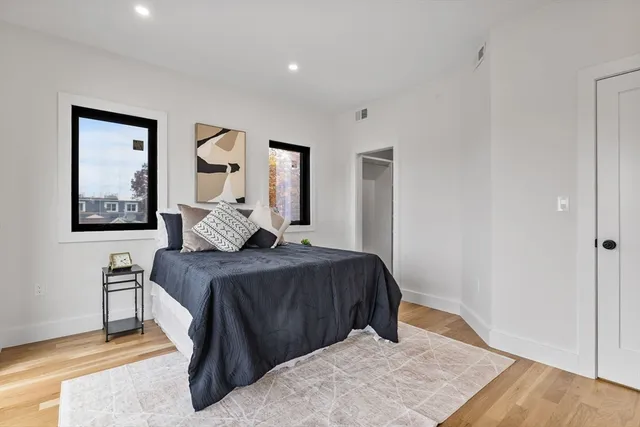 a bedroom with a bed and wooden floor