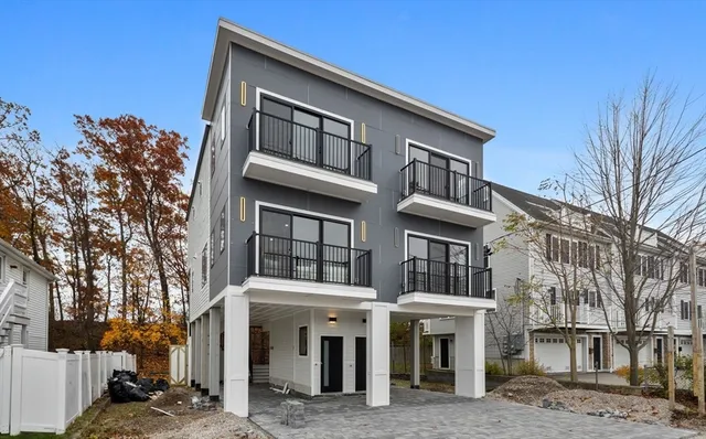a front view of a residential apartment building with a yard