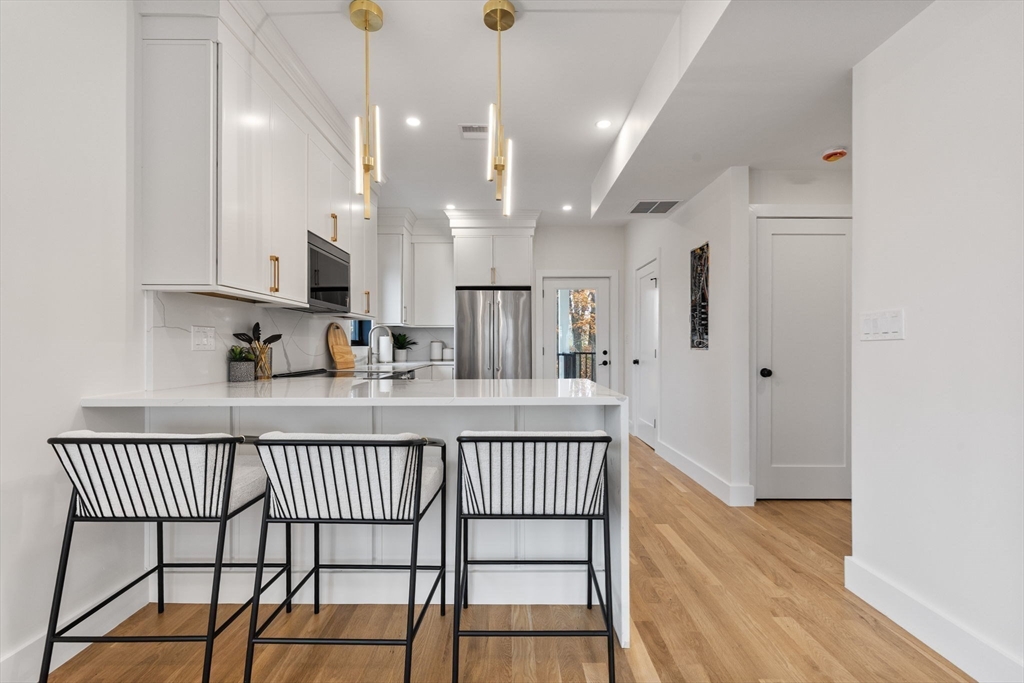 599 Sea Street, Unit 1 Quincy, MA 02169 - Photo 5 of 37 a view of a kitchen with wooden floor and a window