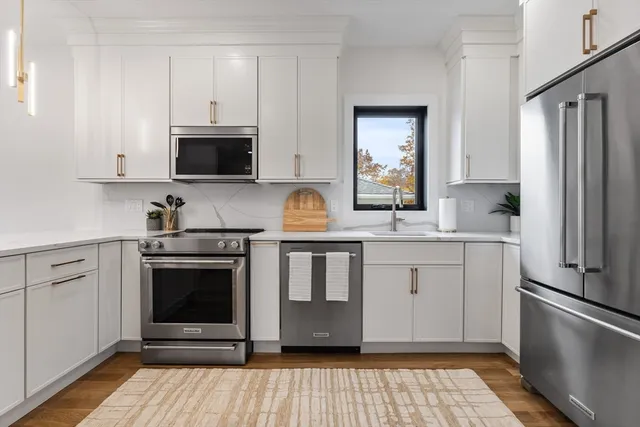 a kitchen with stainless steel appliances granite countertop a stove a sink and a refrigerator