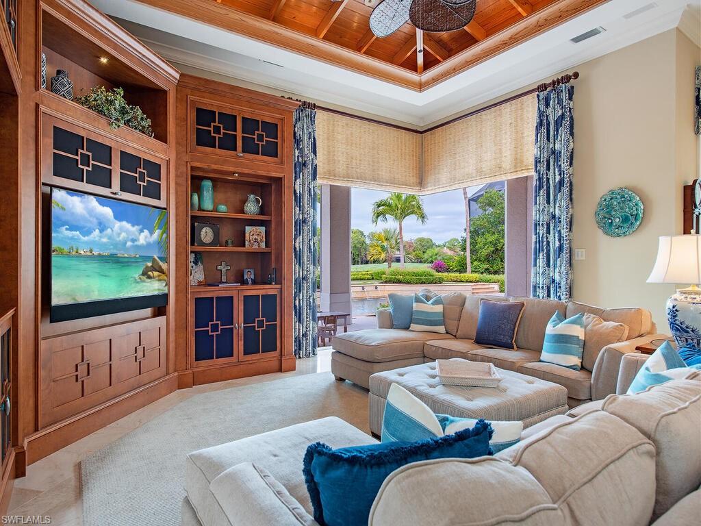 3123 Dahlia Way Naples, FL 34105 - Photo 12 of 29 a living room with furniture a bookshelf and a large window