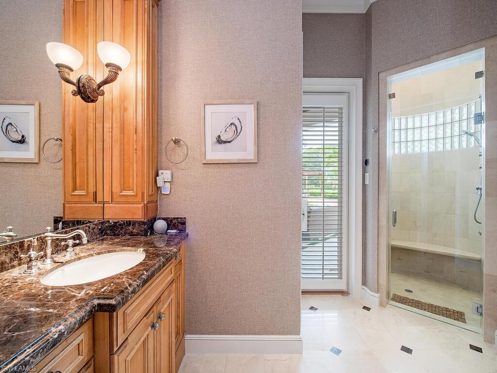 3123 Dahlia Way Naples, FL 34105 - Photo 20 of 29 a bathroom with a granite countertop sink a mirror and a shower