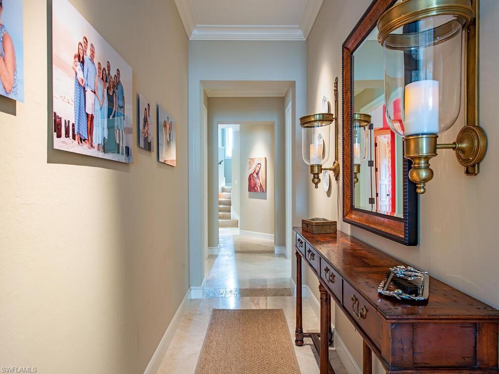 3123 Dahlia Way Naples, FL 34105 - Photo 21 of 29 a hallway with painting on the wall and a mirror