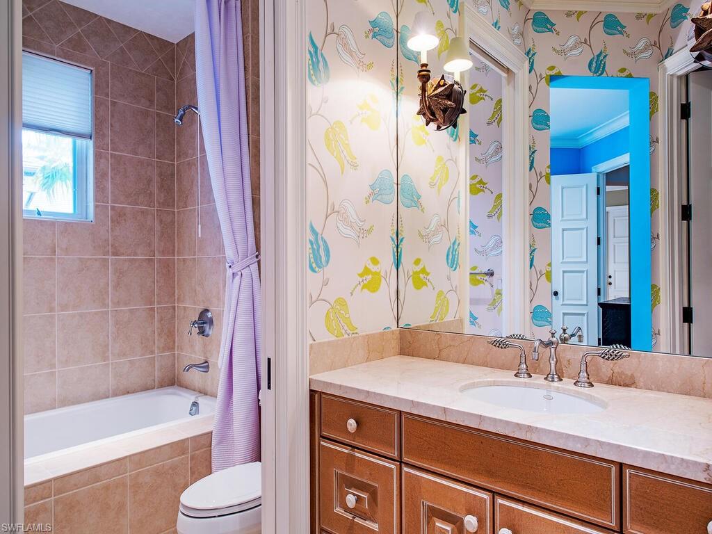 3123 Dahlia Way Naples, FL 34105 - Photo 25 of 29 a bathroom with a granite countertop sink a toilet a bathtub and shower