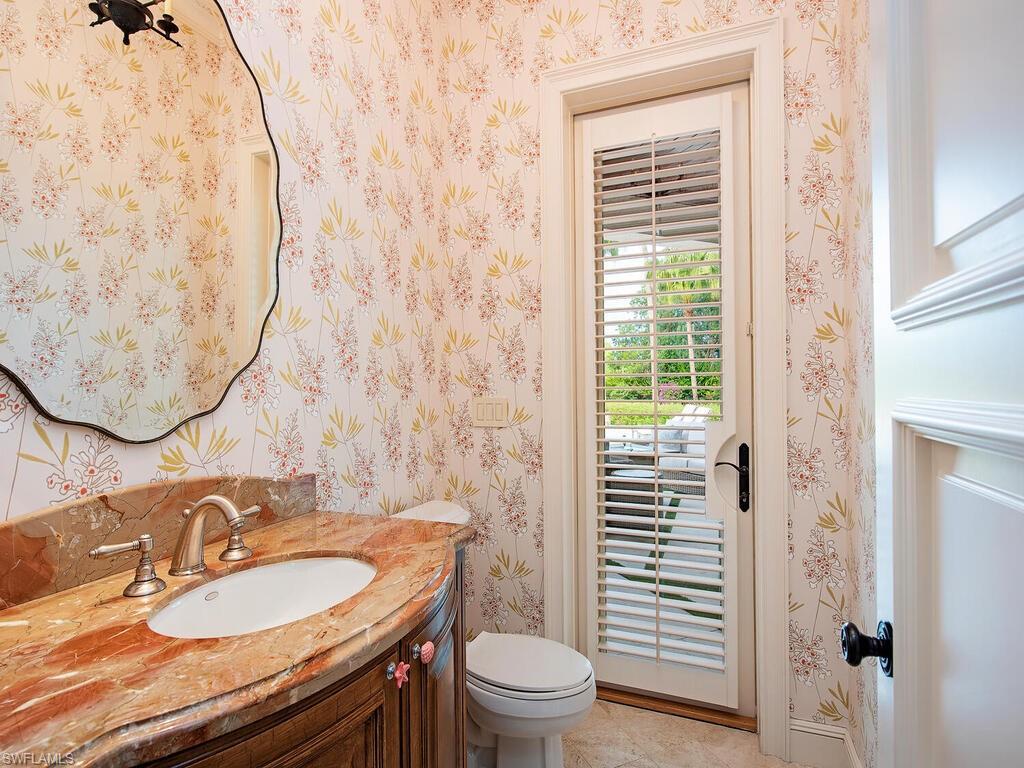 3123 Dahlia Way Naples, FL 34105 - Photo 27 of 29 a bathroom with a granite countertop toilet a sink and a mirror