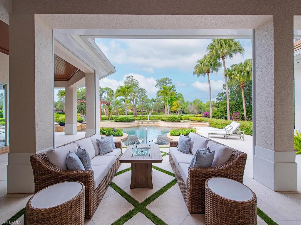 3123 Dahlia Way Naples, FL 34105 - Photo 8 of 29 a living room with patio furniture and a floor to ceiling window
