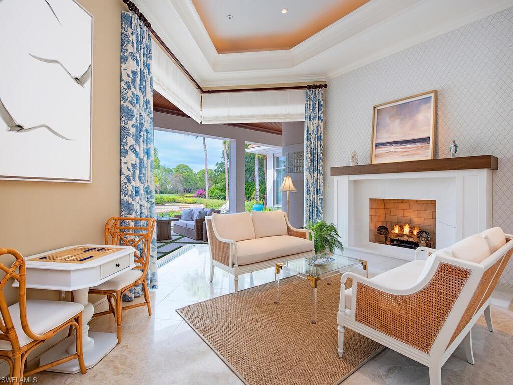 3123 Dahlia Way Naples, FL 34105 - Photo 10 of 29 a living room with furniture a fireplace and a large window