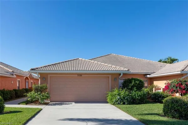 a front view of house with a garden