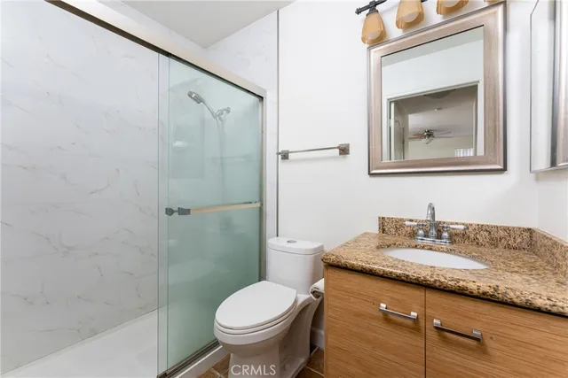 a bathroom with a granite countertop sink toilet and shower