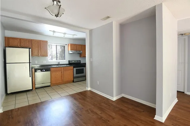 a kitchen with wooden floors and white appliances