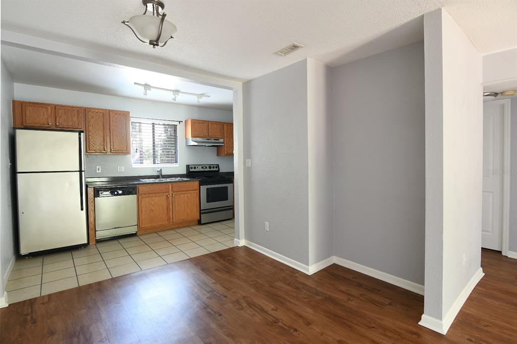 507 Northwest 39th Road, Unit 215 Gainesville, FL 32607 - Photo 5 of 21 a kitchen with wooden floors and white appliances