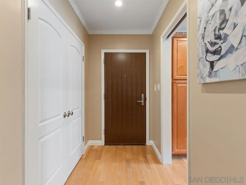 230 Prospect Street, Unit 17 La Jolla, CA 92037 - Photo 12 of 25 a view of a hallway with wooden floor and a bathroom