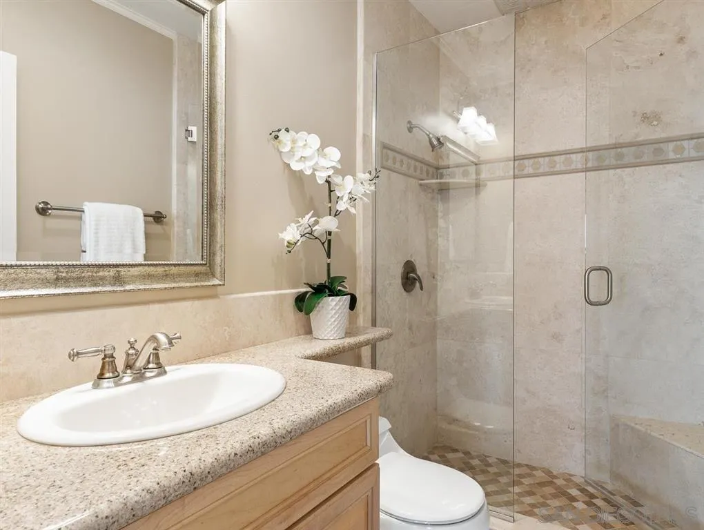 230 Prospect Street, Unit 17 La Jolla, CA 92037 - Photo 13 of 25 a bathroom with a granite countertop sink toilet and shower