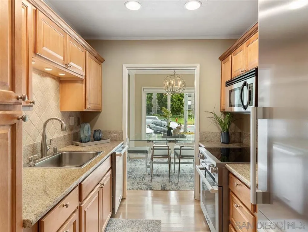 230 Prospect Street, Unit 17 La Jolla, CA 92037 - Photo 9 of 25 a kitchen with a sink and a refrigerator