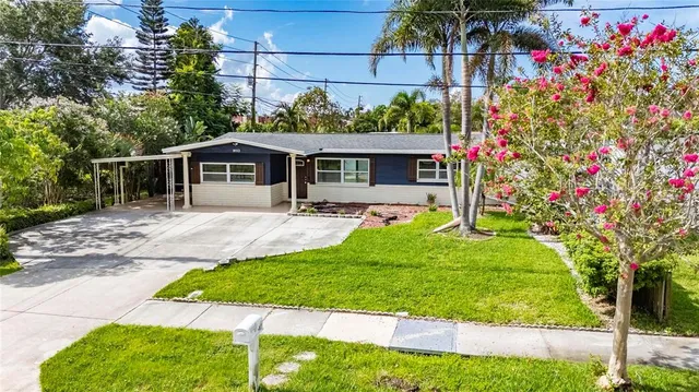 a front view of a house with a yard and potted plants