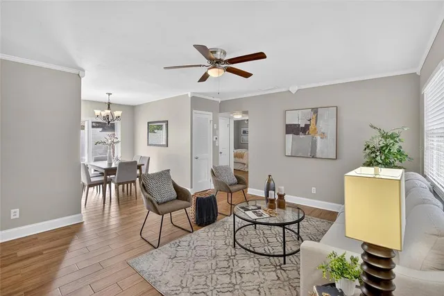 a living room with furniture and a dining table with wooden floor