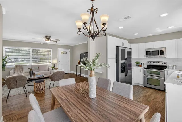 a view of a dining room with furniture a potted plant and wooden floor
