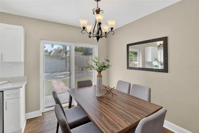 a view of a dining room with furniture a chandelier and wooden floor