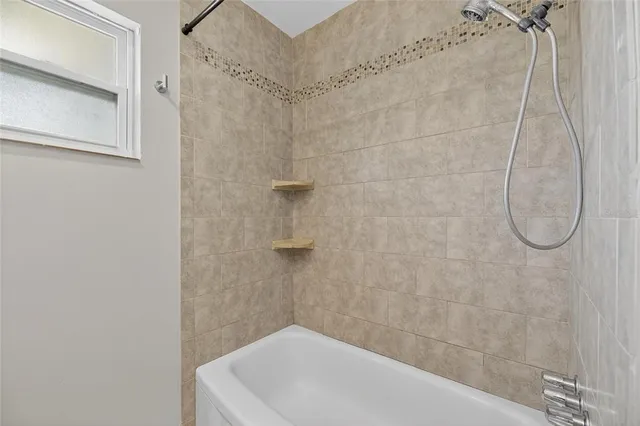 a bathroom with a white bath tub and a shower