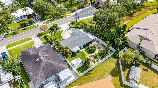 an aerial view of a house with a yard and tennis court