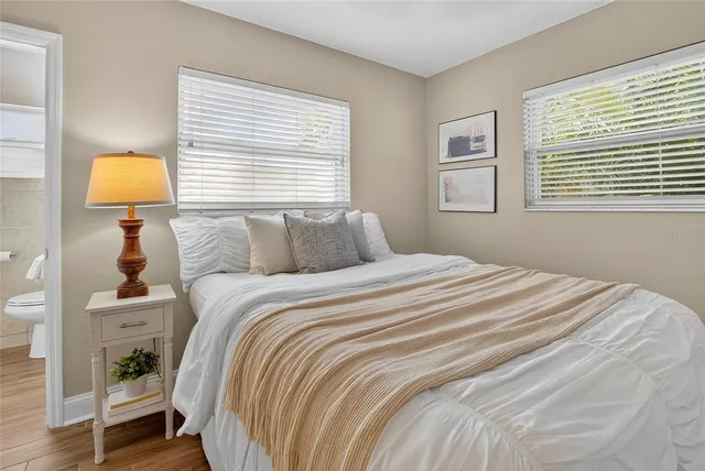 a bedroom with a bed and a lamp on next to a window