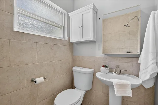a bathroom with a toilet sink and mirror