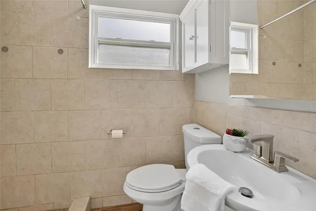 a white toilet sitting next to a bathroom sink