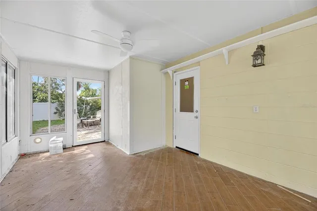 a view of a big room with windows and chandelier fan