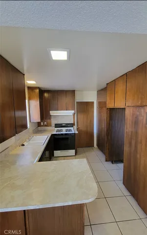 a kitchen with granite countertop a refrigerator and a sink