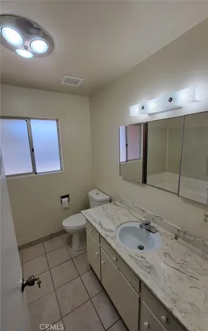 a bathroom with a granite countertop sink mirror vanity and toilet