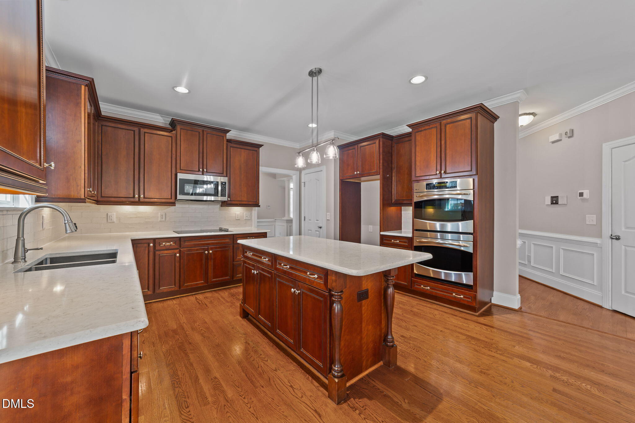1405 Wakefield Farm Road Zebulon, NC 27597 - Photo 55 of 64 a kitchen with stainless steel appliances granite countertop a sink a stove and a wooden floors