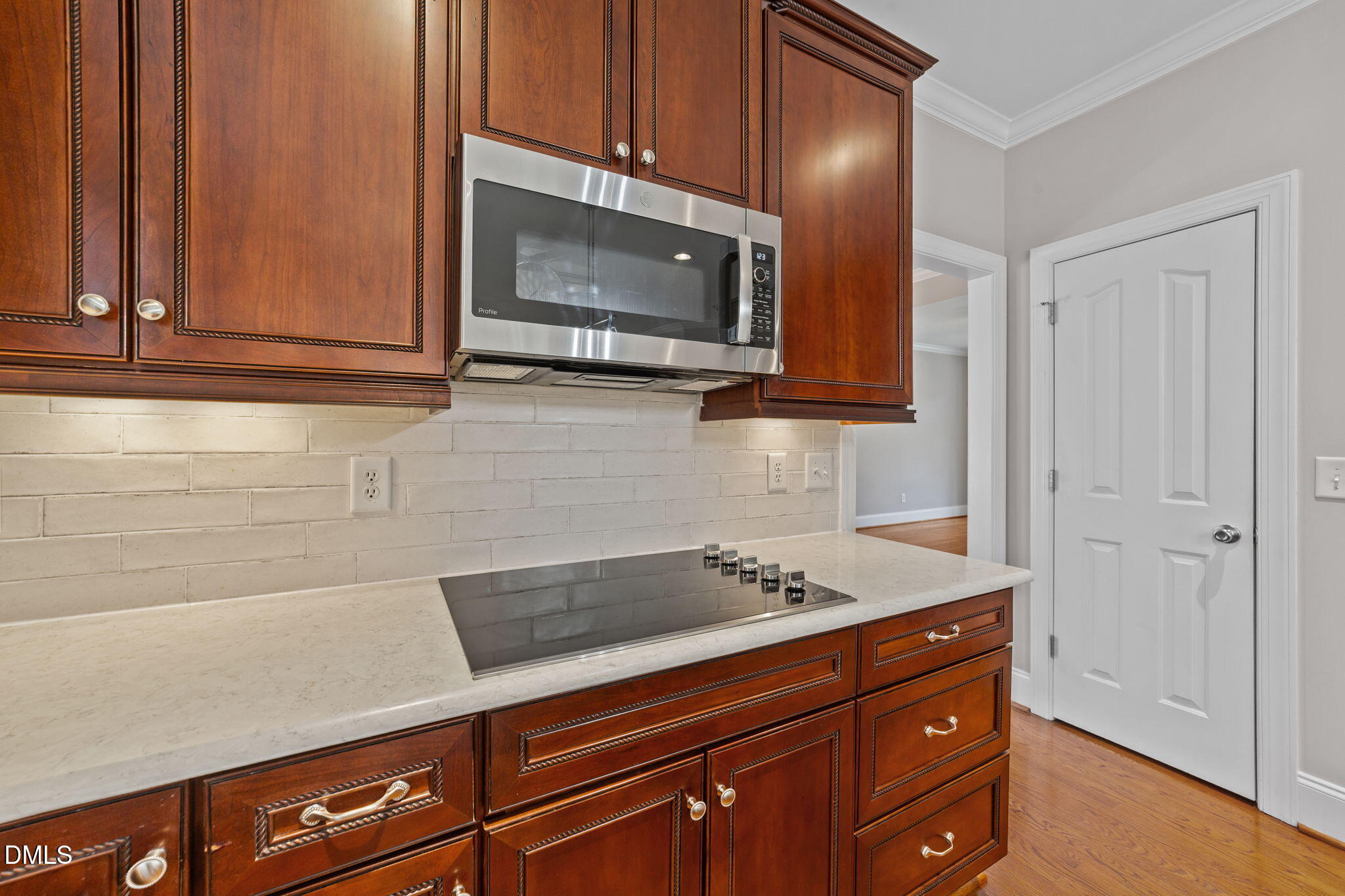 1405 Wakefield Farm Road Zebulon, NC 27597 - Photo 56 of 64 a kitchen with granite countertop cabinets stainless steel appliances and wooden floor