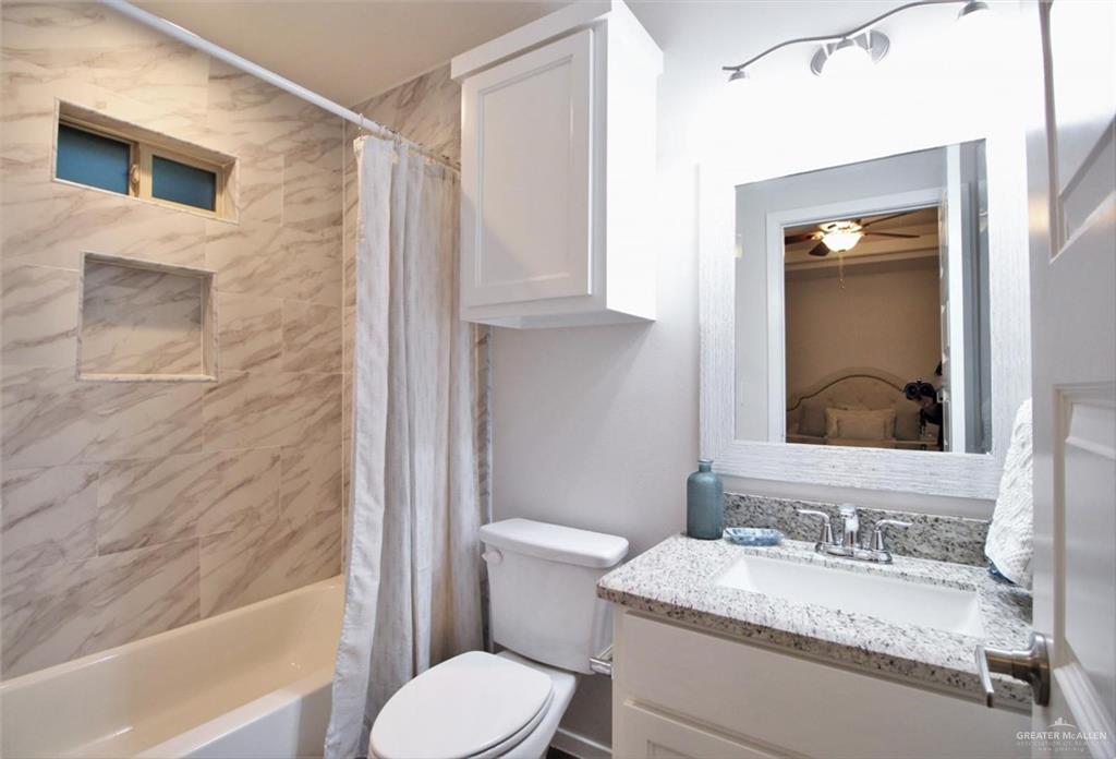 807 Cathedral Hill, Unit 1 Edinburg, TX 78541 - Photo 8 of 11 Bathroom featuring shower / bathtub combination with curtain, vanity, and a ceiling fan
