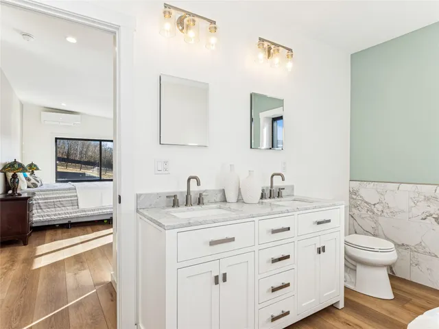 a bathroom with a granite countertop sink mirror and toilet