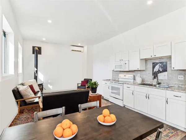 a kitchen with stainless steel appliances kitchen island granite countertop a sink and white cabinets
