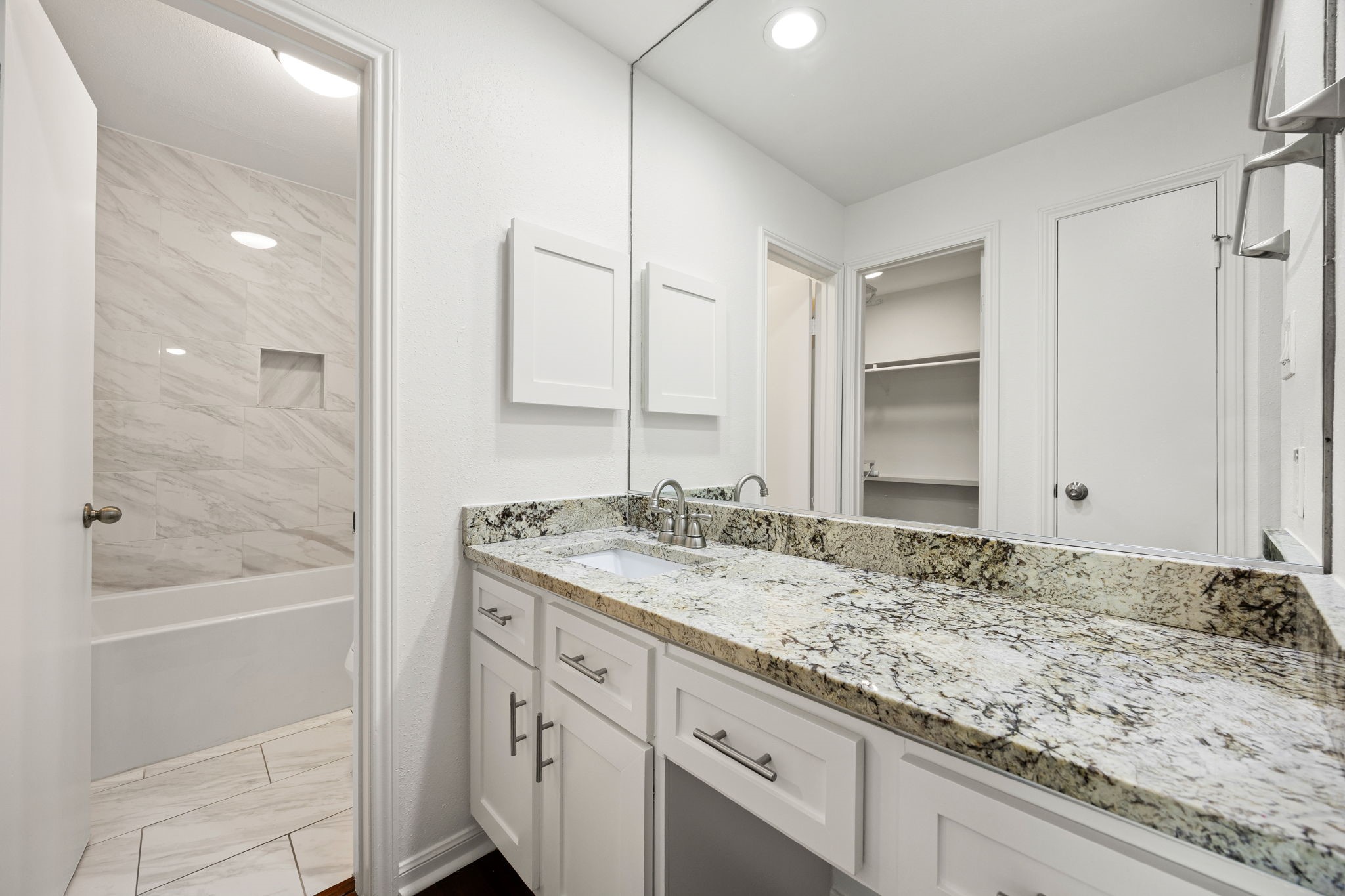 2829 Timmons Lane, Unit 130 Houston, TX 77027 - Photo 11 of 23 a bathroom with a granite countertop sink and a mirror