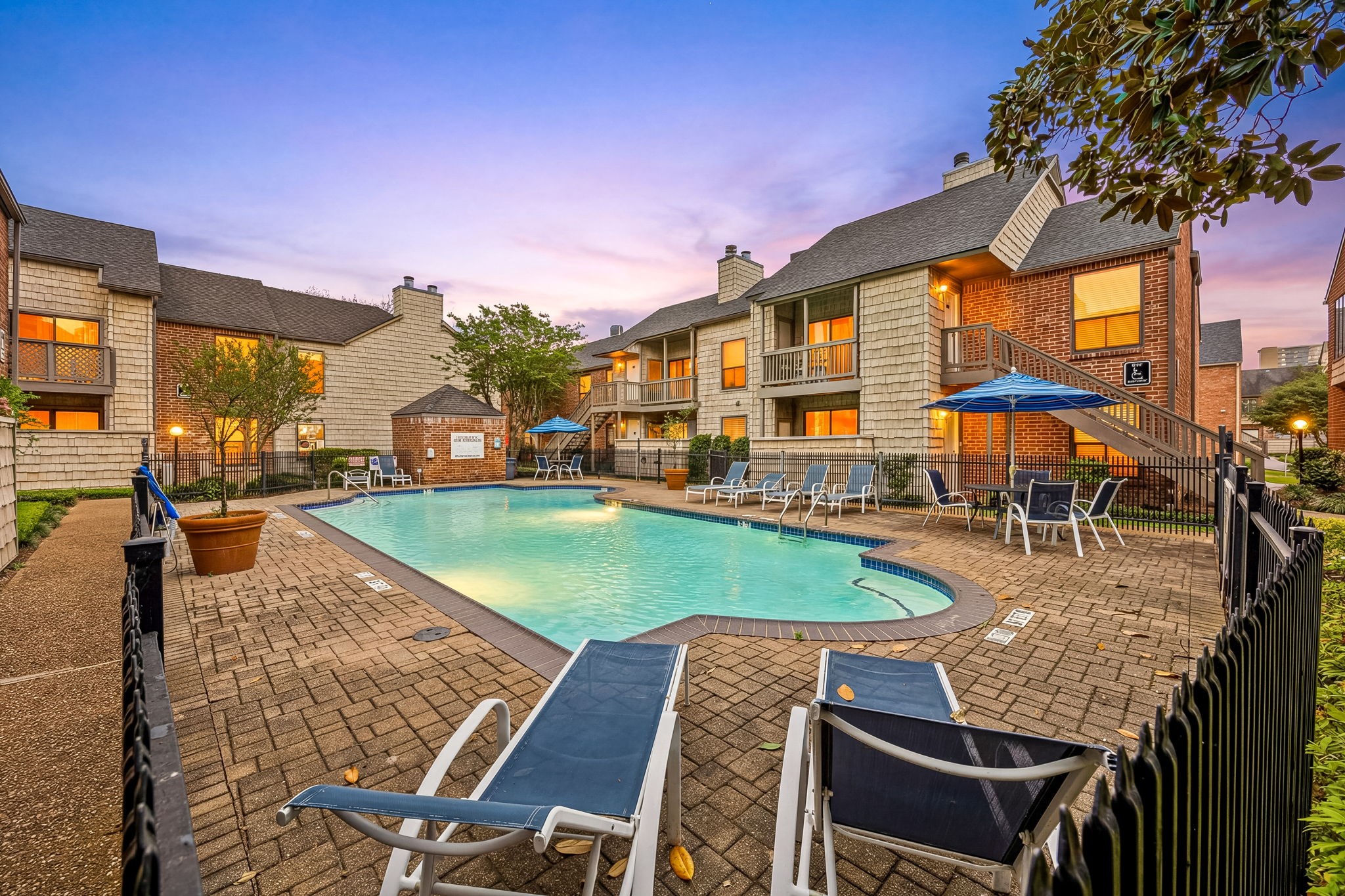 2829 Timmons Lane, Unit 130 Houston, TX 77027 - Photo 21 of 23 a view of a patio with a table and chairs under an umbrella